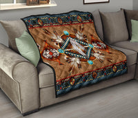 Brown quilt blanket with turquoise bead circles and central white feather motif, dark patterned edge