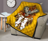 Yellow owl quilt over gray sofa with dreamcatcher center, white feathers, black-edged border