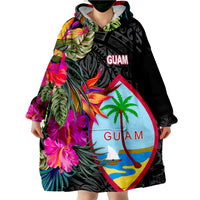 Wearable blanket hoodie on person, black Guam floral and palm print with bright hibiscus
