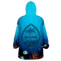 Blue wearable blanket hoodie, back shows Guam emblem with palm, fish and coral