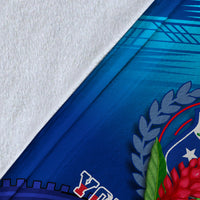 Close-up of blue blanket fabric with crest laurel print and white patterned edge