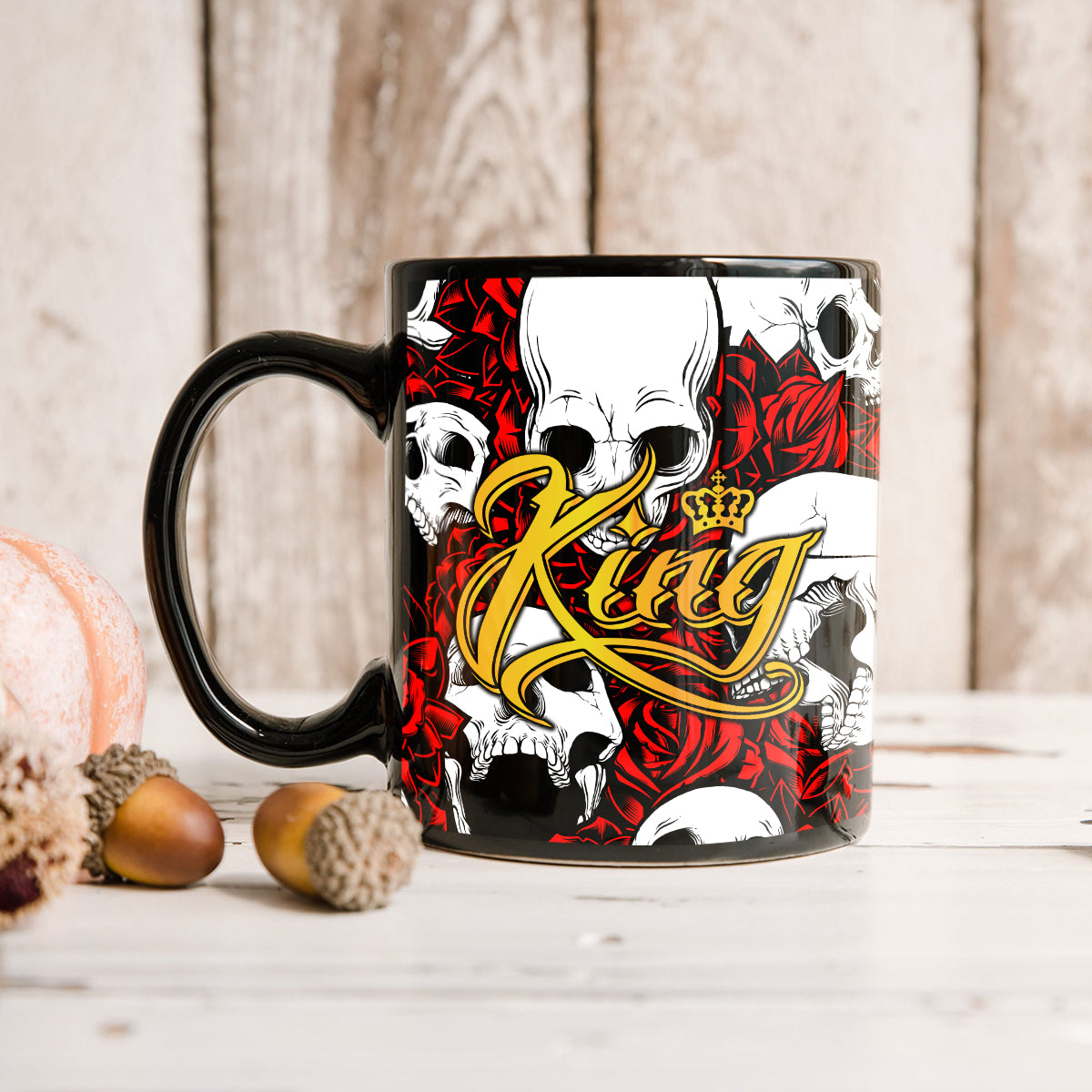 Black ceramic mug with skull and roses graphic on front, gold crown lettering