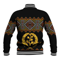 Black baseball jacket back with multicolor geometric cross yoke, gold tree emblem, striped ribbed hem