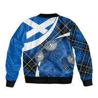 Blue bomber jacket with tartan plaid back and thistle graphic, ribbed hem and cuffs