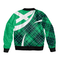 Back of green plaid bomber jacket with large white cross print and black ribbed cuffs.