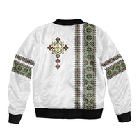 White bomber jacket back with vertical patterned stripe, cross motif, and black ribbed hem