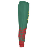 Green jogger pants side view with red camo print on lower legs and red ribbed cuffs