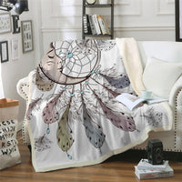 White throw blanket with dreamcatcher moon and feather print, teal bead accents, draped