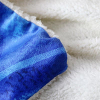 Multicolor blanket corner with blue gradient wolf-like print and soft white backing