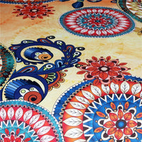 Close-up tapestry detail with red flower center and blue bird motifs on warm beige