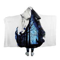 Hooded blanket with blue-and-black wolf and tree print, white hood backing