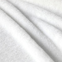 Close-up of white plush lining fabric on a hooded blanket