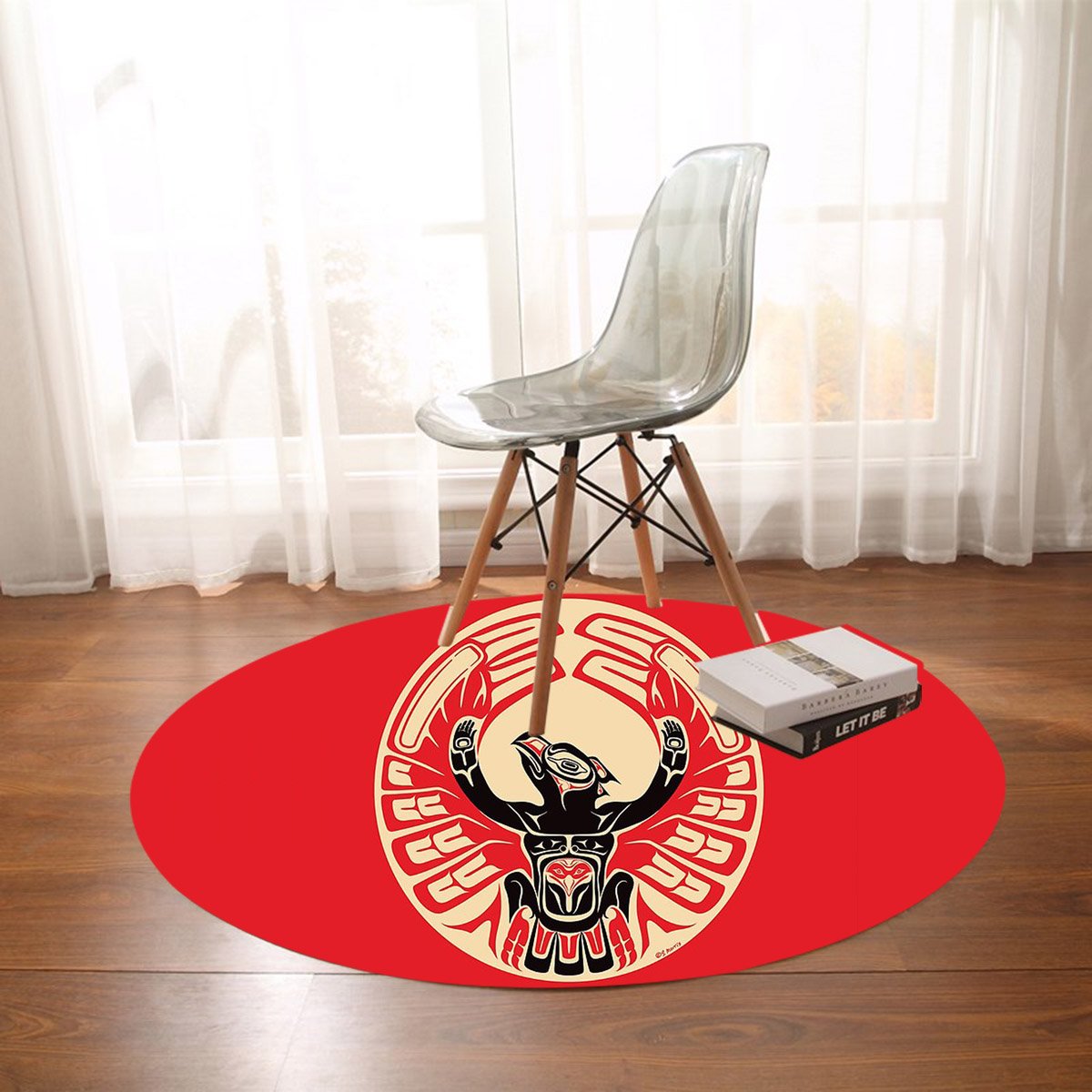 Red round thunderbird rug with black, cream, and beige tribal design under a chair