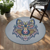 Round stylized wolf face rug in colorful decorative pattern on light blue
