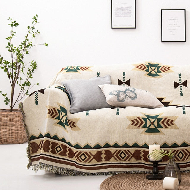 Cream Aztec sofa blanket cover with teal arrow motifs, diamond border, and fringed hem