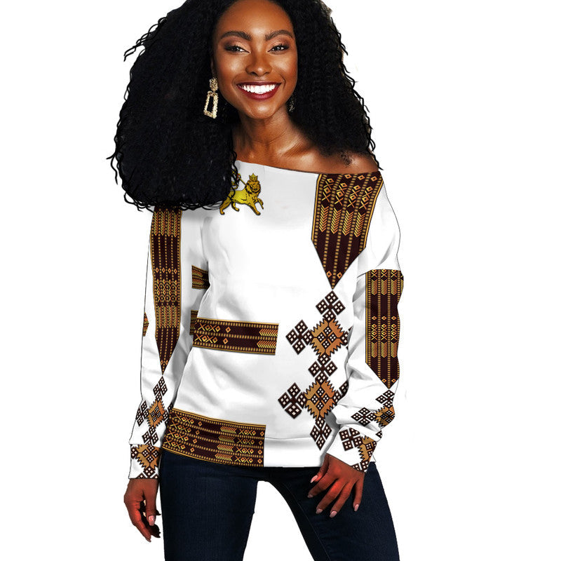 Off-shoulder women’s sweater in white with Ethiopian lion and geometric pattern