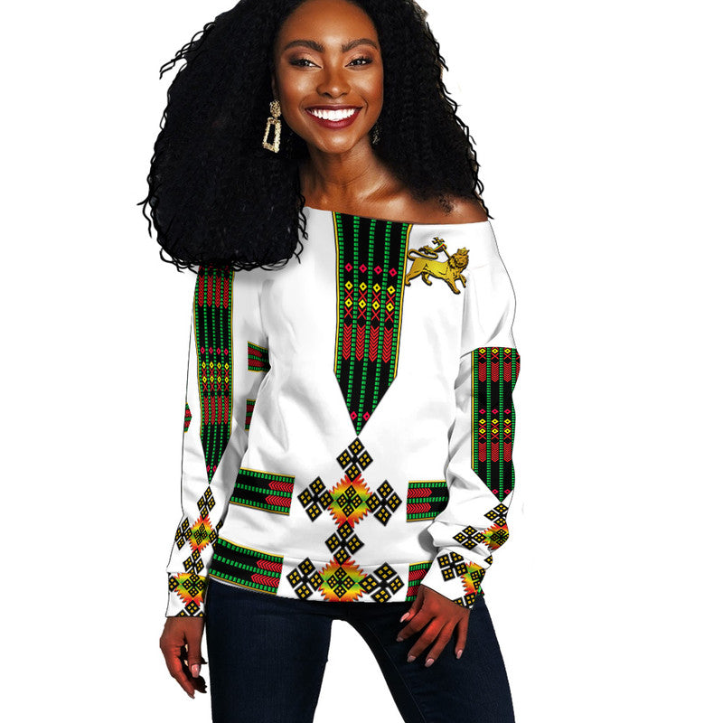 White off-shoulder sweater with Ethiopian lion print and patterned cuffs