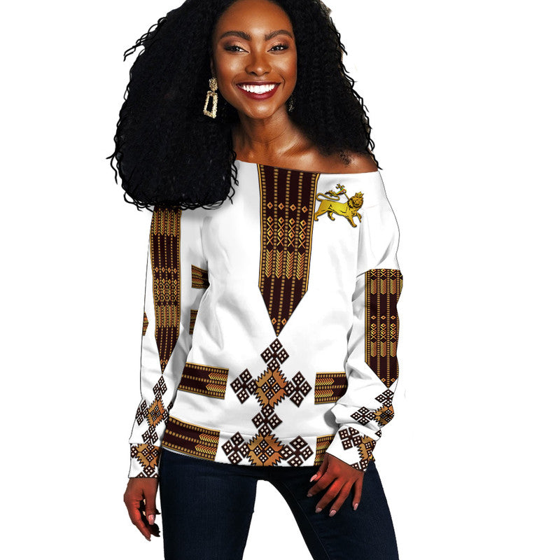 Women’s off-shoulder sweater, white with gold-brown Ethiopian lion and tribal print