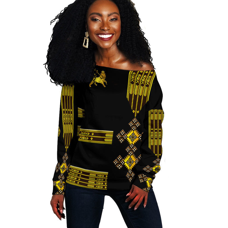 Black off-shoulder sweater with gold Ethiopian patterns and lion print, long sleeves