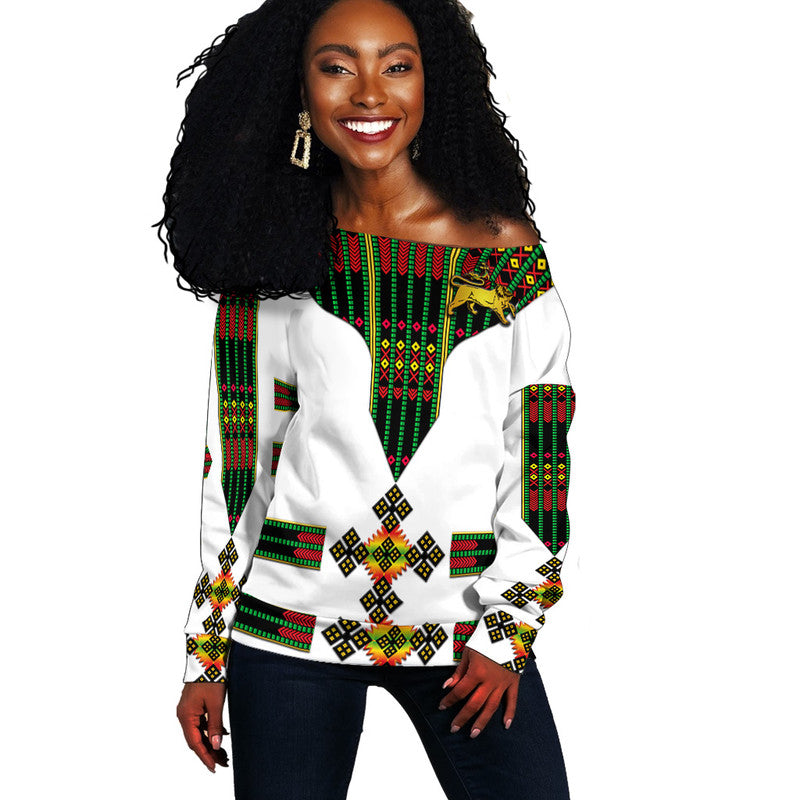 White off-shoulder women’s sweater with Ethiopian flag-style geometric pattern and lion graphic