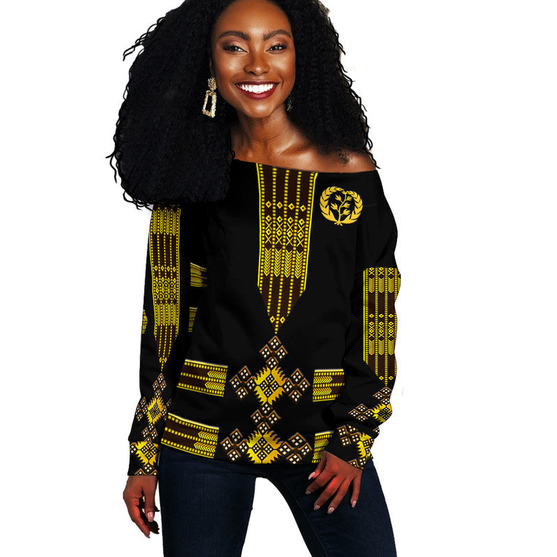 Black off-shoulder sweater with yellow Ethiopian-inspired geometric and leaf motif